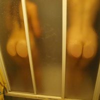 Pair of Naked Buttocks Against the Shower Cabin